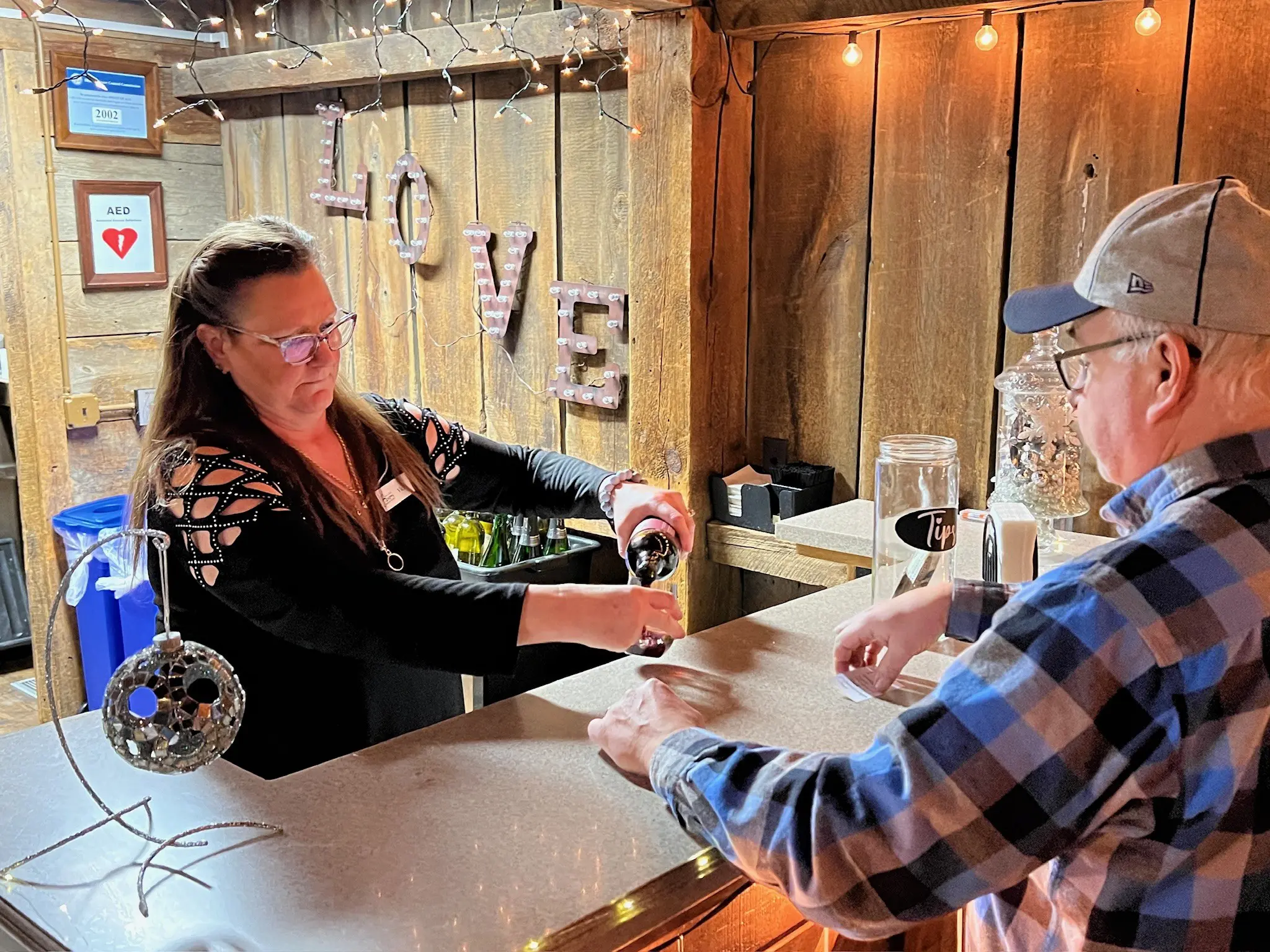 a person and person pouring alcohol into a bar