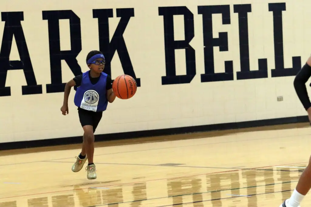 a child playing basketball in a gym