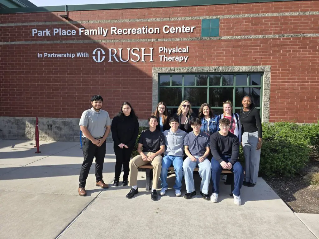 a group of people posing for a photo in front of a brick building