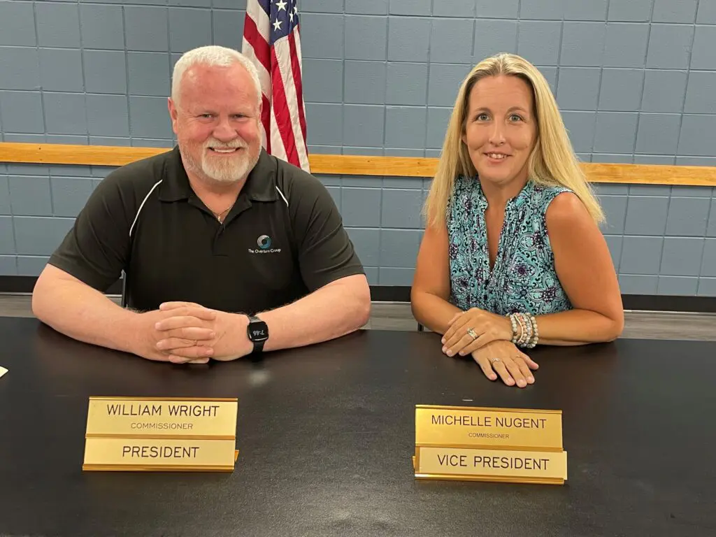 a person and person sitting at a table with name plates