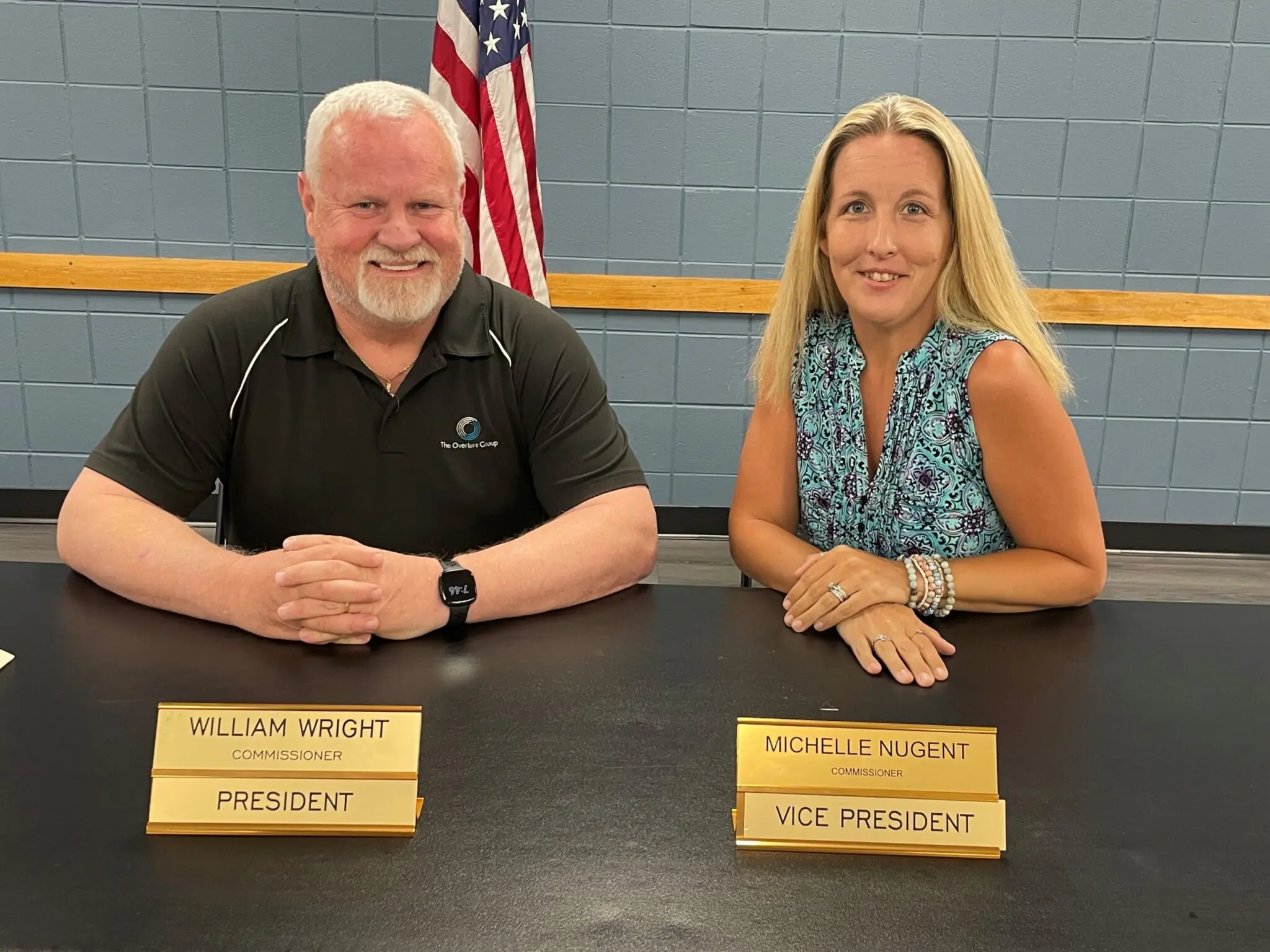 a person and person sitting at a table with name plates