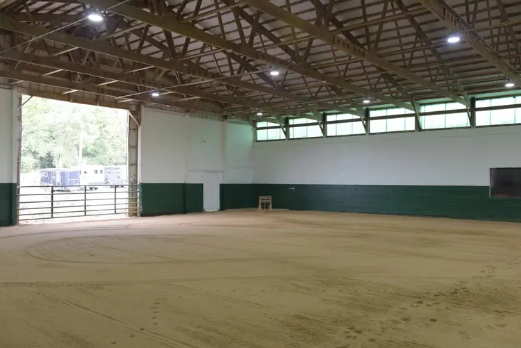 an empty arena with dirt and a fence