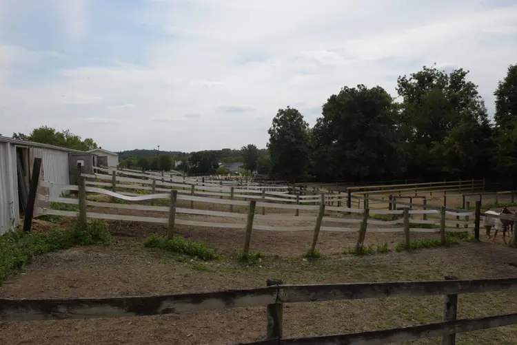 a fenced in field with trees in the background