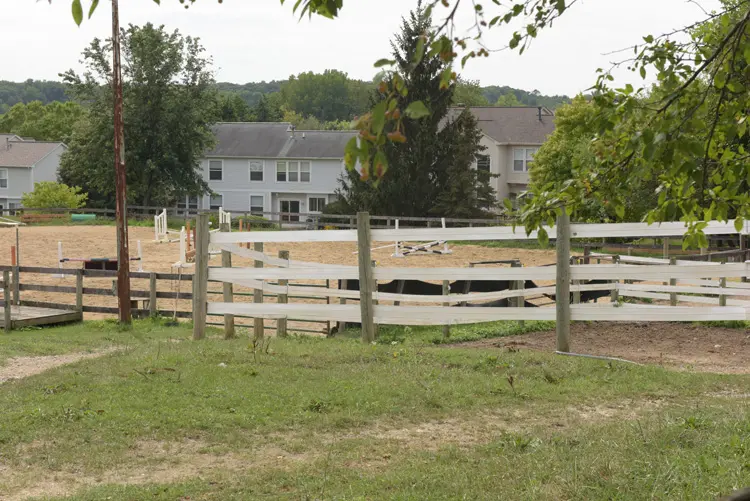 a fenced in area with a dirt field and buildings