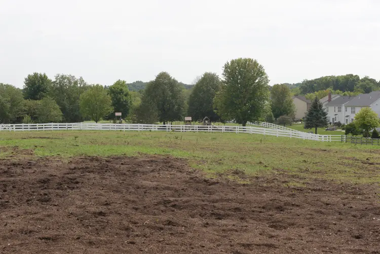 a field with a white fence