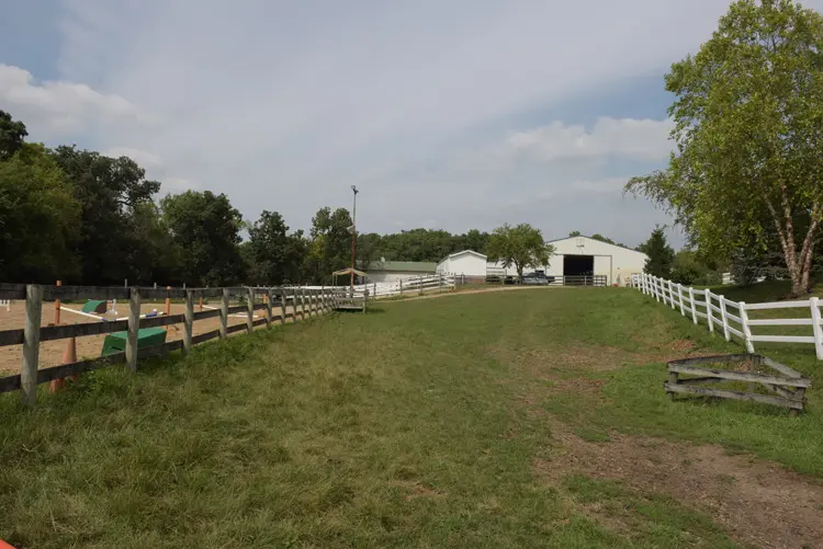 a field with a fence and a building