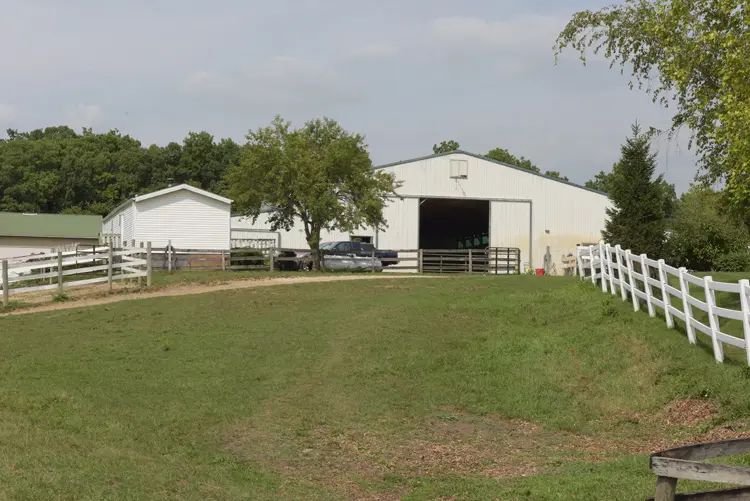 a white building with a fence and a field