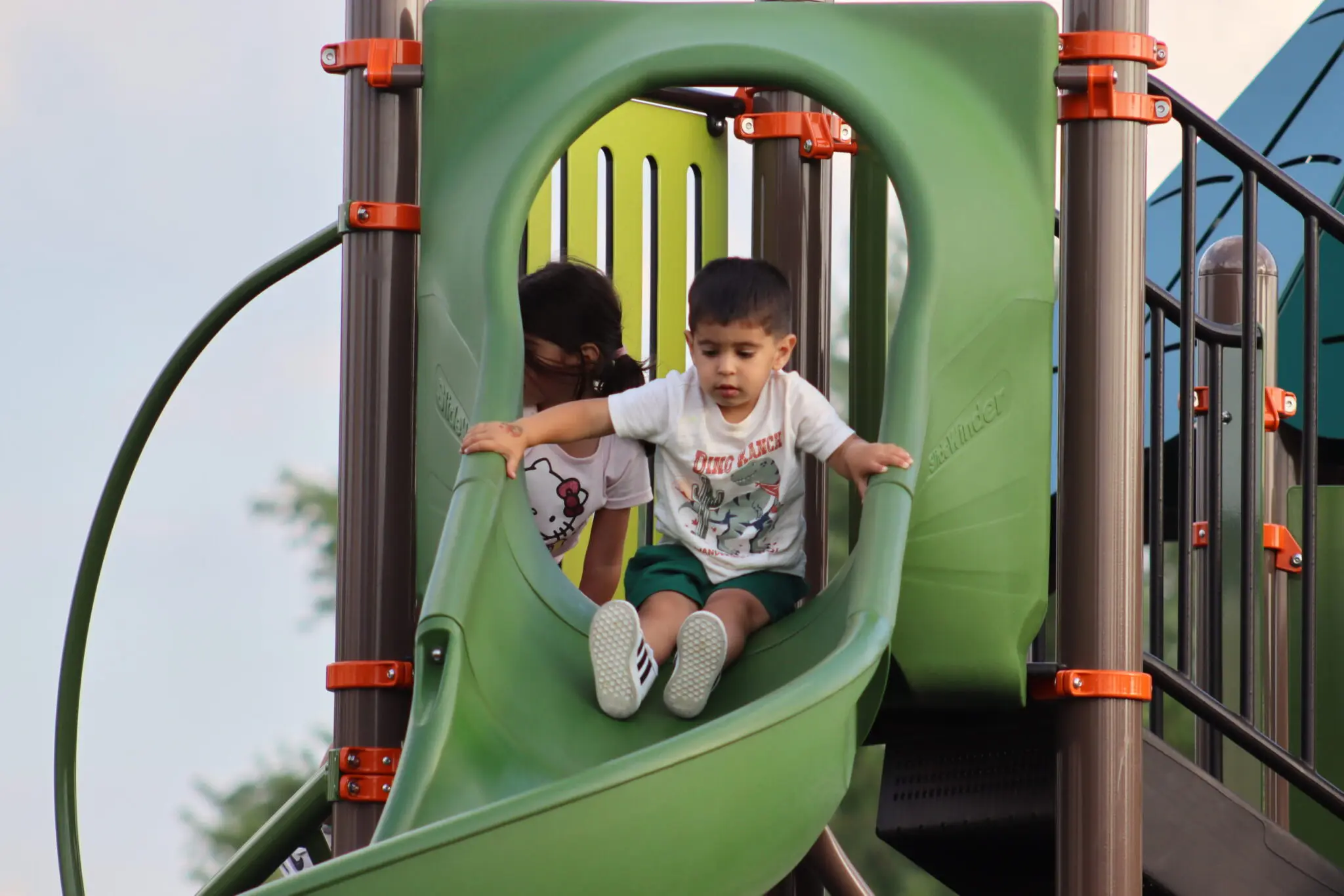 a child and child playing on a slide