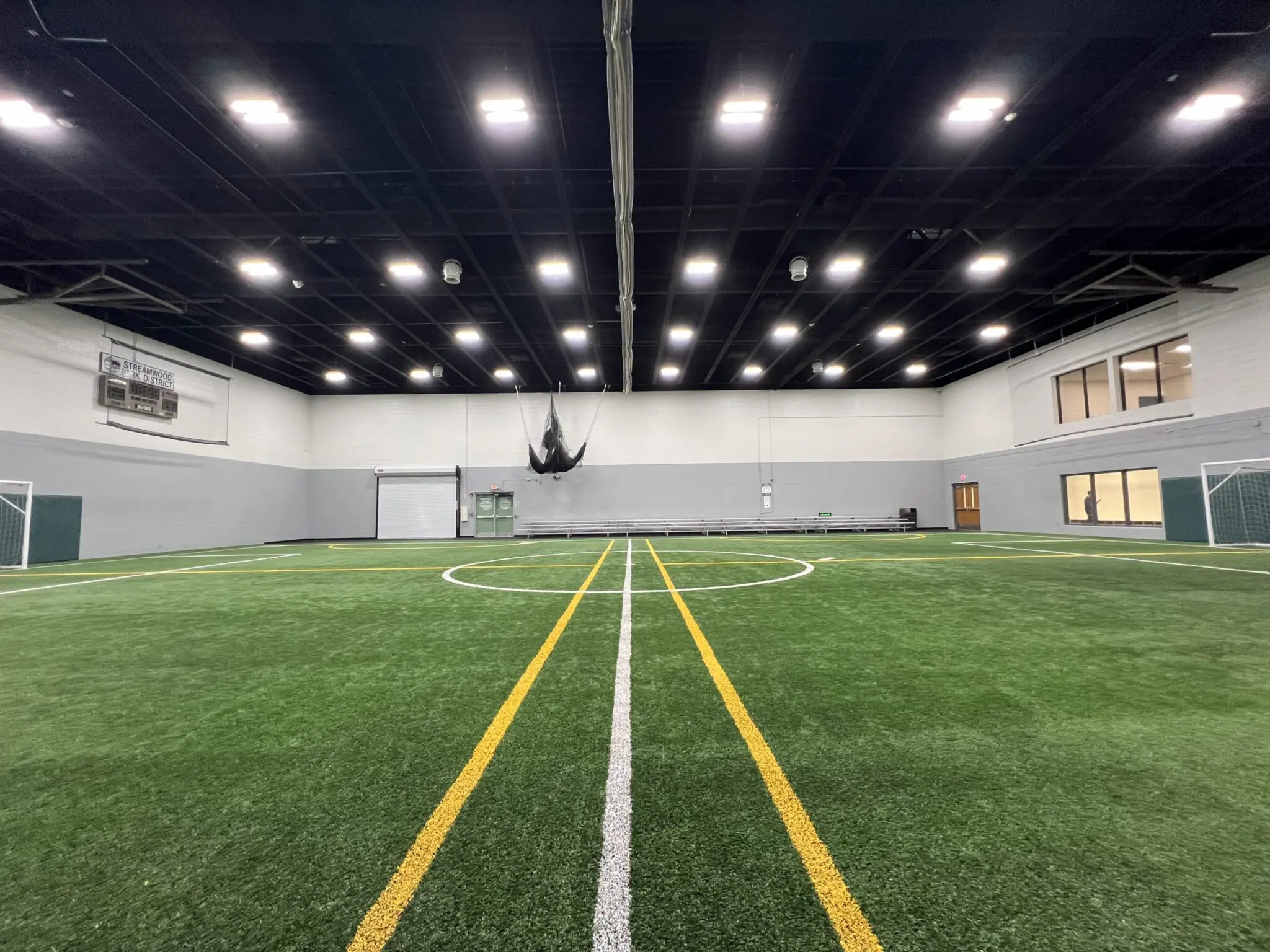 a indoor football field with a white line and yellow lines
