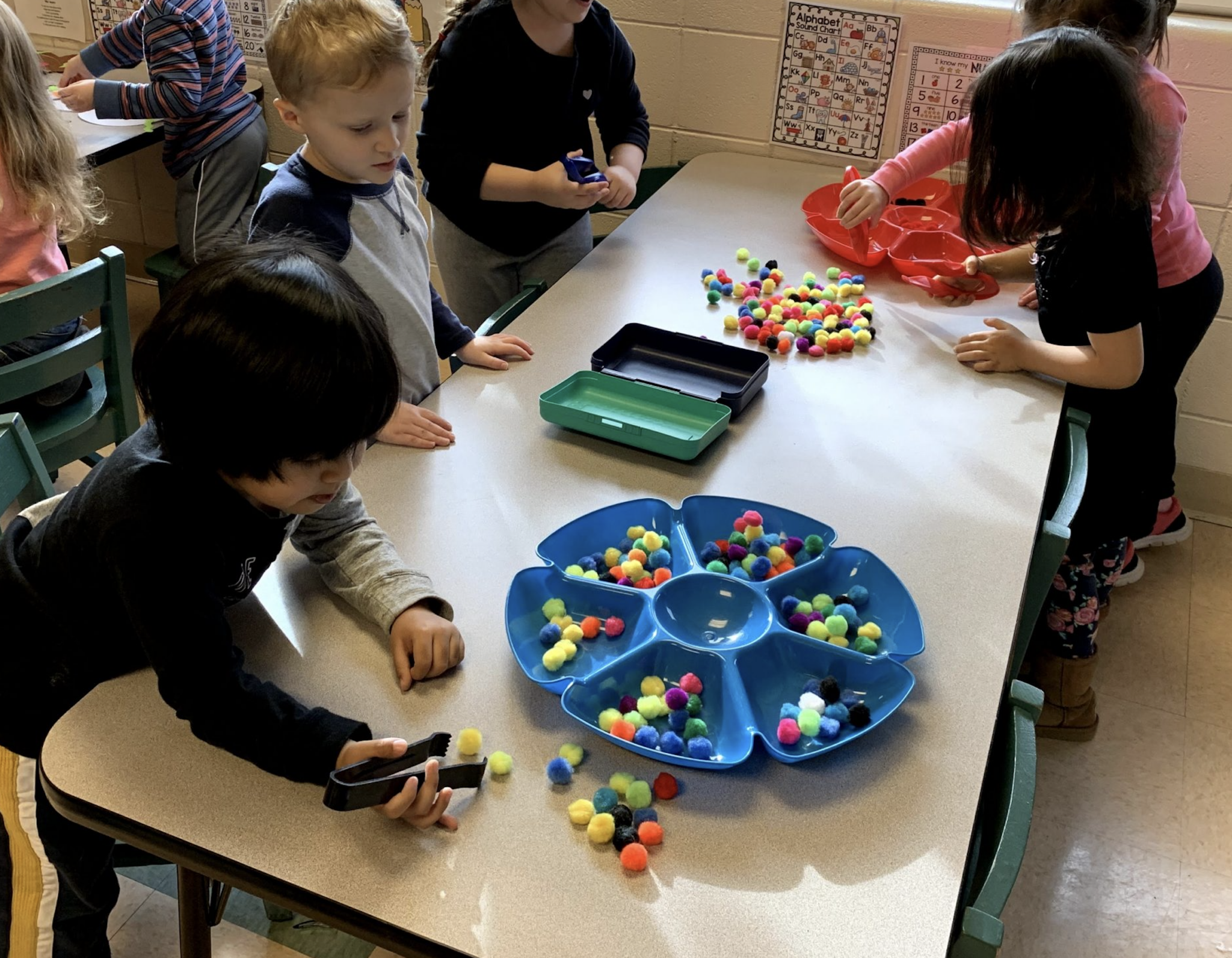 a group of children playing with colorful balls on a table