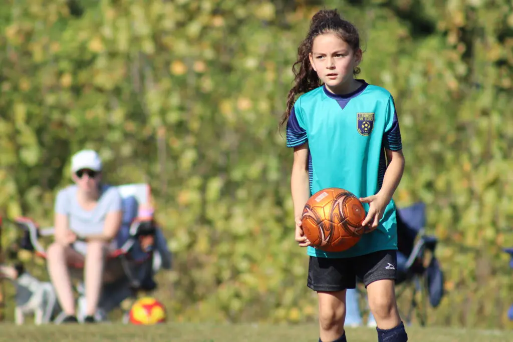a child holding a football ball