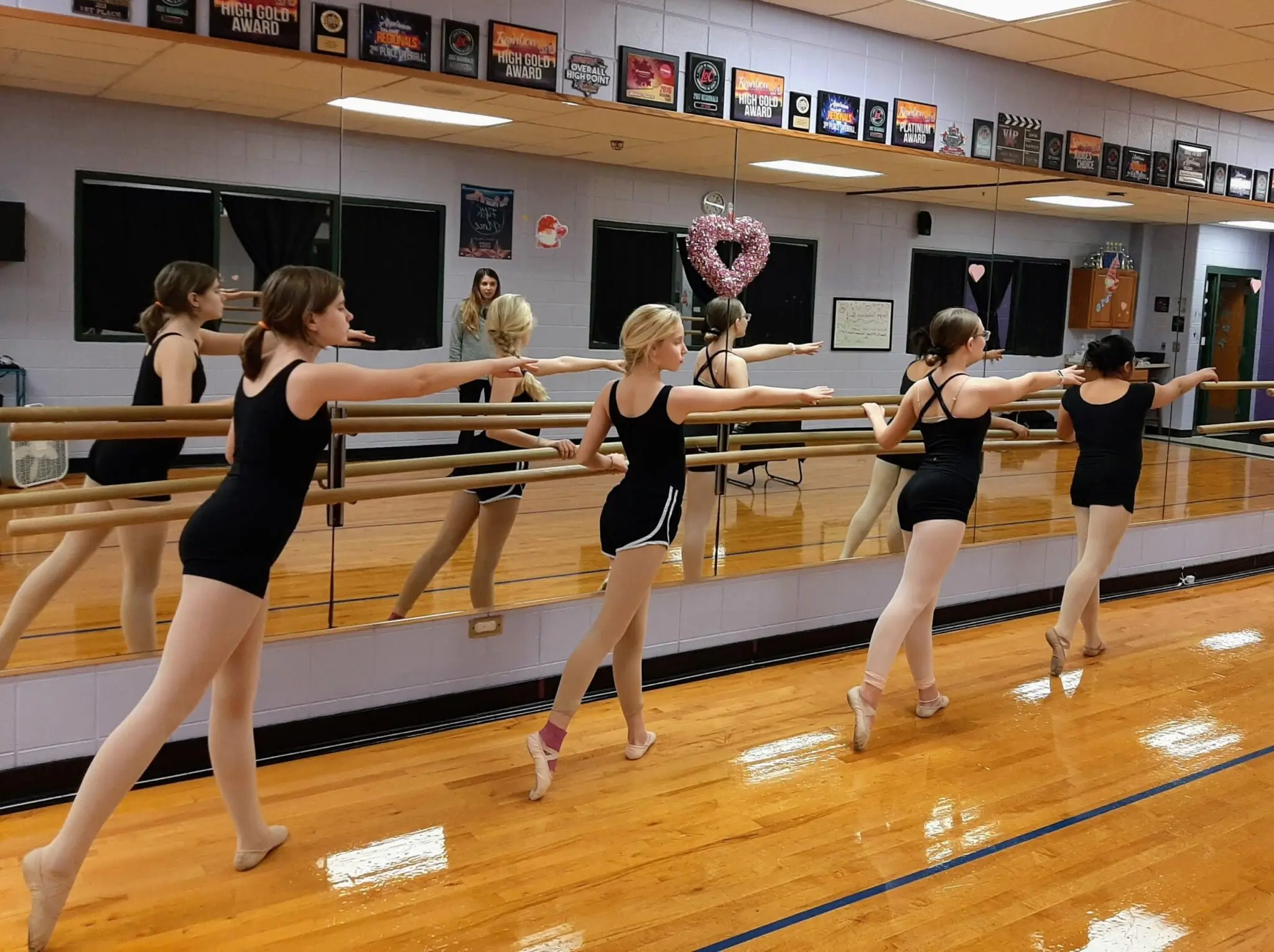 a group of women in black leotards in a gym