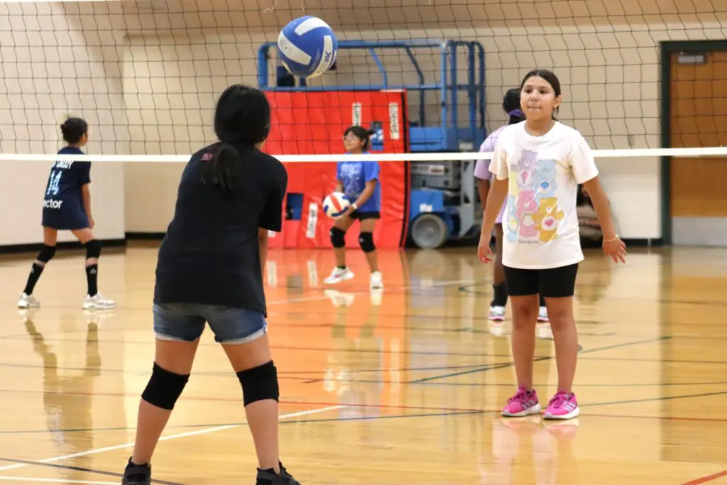 a group of childs playing volleyball