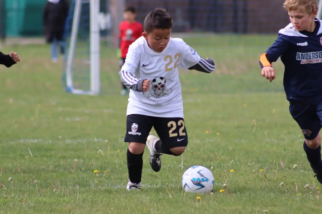 a child kicking a football ball